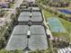 Aerial view of tennis and basketball courts surrounded by trees in a well-maintained community at 30280 Southernwood Ct, Wesley Chapel, FL 33543