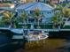 Aerial view of a waterfront property with a private dock, boats, and tropical landscaping at 315 Manatee Ln, Tarpon Springs, FL 34689