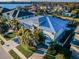 A beautiful two-story home with a metal roof and a manicured lawn is seen from the side, boasting waterfront access at 315 Manatee Ln, Tarpon Springs, FL 34689