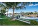 Beautiful waterfront backyard with lush landscaping, a boat dock, and a boat at 315 Manatee Ln, Tarpon Springs, FL 34689