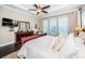 Bright bedroom with a ceiling fan, dark wood floors, dresser, and three large windows at 315 Manatee Ln, Tarpon Springs, FL 34689
