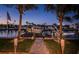 Picturesque waterfront scene with a boat dock and tropical landscaping at 315 Manatee Ln, Tarpon Springs, FL 34689