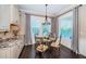 Bright breakfast nook featuring a glass table, window with blinds, and custom cabinetry for added storage at 315 Manatee Ln, Tarpon Springs, FL 34689