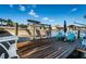 Daytime view of dock with boat lift, blue Adirondack chairs, and calm water, perfect for waterfront living at 315 Manatee Ln, Tarpon Springs, FL 34689