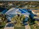 Stunning two-story home featuring a metal roof, lush landscaping, and a brick driveway that leads to a two-car garage at 315 Manatee Ln, Tarpon Springs, FL 34689