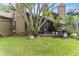 Backyard featuring a lush lawn, mature trees, and a screened patio with a grill; ideal for outdoor living at 318 Parkside Ln, Safety Harbor, FL 34695