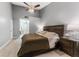 Cozy bedroom with a large bed, ceiling fan, and neutral color scheme, leading to bathroom at 318 Parkside Ln, Safety Harbor, FL 34695