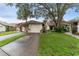 Charming single Gathering home showcasing a well manicured lawn and attached one car garage at 318 Parkside Ln, Safety Harbor, FL 34695