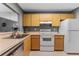 Functional kitchen featuring wood cabinets, white appliances, and ample counter space at 318 Parkside Ln, Safety Harbor, FL 34695