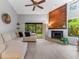 Comfortable living room featuring a stylish fireplace, vaulted ceilings, and sliding glass doors to a patio at 318 Parkside Ln, Safety Harbor, FL 34695
