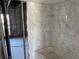 Bathroom's marble-tiled wall above a tub, showcasing the renovation in progress at 329 Medallion Blvd # C, Madeira Beach, FL 33708