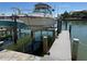 View of boat sitting on a lift at the dock, with water reflections at 329 Medallion Blvd # C, Madeira Beach, FL 33708