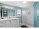 Bathroom features walk-in shower, modern lighting, white cabinetry and blue accent wall at 330 176Th Avenue Cir, Redington Shores, FL 33708