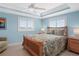 Light-filled bedroom features a ceiling fan, recessed lights, and two windows with bright blue walls at 330 176Th Avenue Cir, Redington Shores, FL 33708