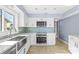 Clean kitchen featuring stainless steel appliances, white cabinets, and blue backsplash tiles at 330 176Th Avenue Cir, Redington Shores, FL 33708