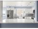 Well-lit kitchen with white cabinets, stainless appliances, and stylish backsplash at 330 176Th Avenue Cir, Redington Shores, FL 33708
