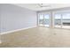 Bright living area with tile flooring, a ceiling fan, and sliding doors opening to waterfront views at 330 176Th Avenue Cir, Redington Shores, FL 33708