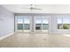 Spacious room with tile flooring, a ceiling fan, and sliding doors that open to waterfront views at 330 176Th Avenue Cir, Redington Shores, FL 33708