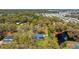 Aerial view of the home nestled amidst a lush, green landscape with a pond nearby, offering privacy at 37350 Neighbors Path, Zephyrhills, FL 33542