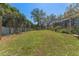 Backyard with a large grassy area, garden beds, and mature trees at 37350 Neighbors Path, Zephyrhills, FL 33542