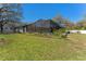 A lush backyard with a screen enclosure and partial view of the home's exterior at 37350 Neighbors Path, Zephyrhills, FL 33542