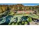 Aerial view of basketball and tennis courts next to playground with mature trees and community pond at 3798 Darston St, Palm Harbor, FL 34685