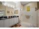 Bright bathroom featuring dual sinks with granite counters, glass enclosed shower, and contemporary lighting at 3798 Darston St, Palm Harbor, FL 34685