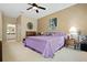 Spacious primary bedroom featuring neutral walls, plush carpet, a purple bedspread, and attached bath at 3798 Darston St, Palm Harbor, FL 34685