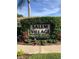 The community sign for Salem Village surrounded by lush, mature greenery at 3798 Darston St, Palm Harbor, FL 34685