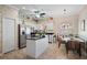 Eat-in kitchen featuring white cabinets, granite counters, stainless steel appliances, and dining space with unique decorations at 3798 Darston St, Palm Harbor, FL 34685