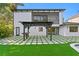 A spacious backyard featuring artificial turf, an outdoor pergola, and dark trim windows at 4308 W Beach Park Dr, Tampa, FL 33609