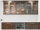 Stylish bar area with wooden cabinets, glass doors, quartz counters, gold hardware, and built-in wine cooler at 4308 W Beach Park Dr, Tampa, FL 33609