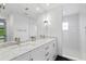 Bright bathroom featuring dual sinks with marble countertop and a glass shower with white tile at 4308 W Beach Park Dr, Tampa, FL 33609