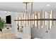 Modern open-concept dining room featuring a unique chandelier and views to the fireplace and living room at 4308 W Beach Park Dr, Tampa, FL 33609