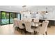 Elegant dining room features a long table, ten chairs, and sliding glass doors to the outdoor patio and pool at 4308 W Beach Park Dr, Tampa, FL 33609