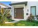 Charming front entrance with modern dark wood door, well manicured landscaping, and verdant greenery at 4308 W Beach Park Dr, Tampa, FL 33609