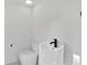 A minimalist half-bathroom featuring unique pedestal sink and modern toilet at 4308 W Beach Park Dr, Tampa, FL 33609