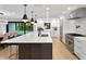Modern kitchen with a large island, stainless steel appliances, black pendant lights, and views to the pool at 4308 W Beach Park Dr, Tampa, FL 33609