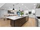 Modern kitchen with a large quartz island, stainless steel appliances, and dark hardwood cabinets and gold pulls at 4308 W Beach Park Dr, Tampa, FL 33609