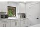 Bright kitchen with white cabinets, quartz countertop, stainless steel appliances, and views to the backyard at 4308 W Beach Park Dr, Tampa, FL 33609