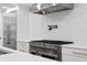 Close up on a modern kitchen with stainless steel appliances, pot filler faucet, and white quartz backsplash at 4308 W Beach Park Dr, Tampa, FL 33609