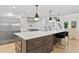 Modern kitchen with a quartz island, stainless steel appliances, black pendant lights, and dark hardwood cabinets at 4308 W Beach Park Dr, Tampa, FL 33609