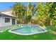Backyard featuring a pool surrounded by tropical plants and a home with dark trim windows at 4308 W Beach Park Dr, Tampa, FL 33609