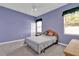 Bedroom with lavender painted walls, carpet floors, two windows, a bed and a dresser at 4823 Deer Lodge Rd, New Port Richey, FL 34655