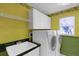 Laundry room with white cabinets, dark countertop and modern washer and dryer at 4823 Deer Lodge Rd, New Port Richey, FL 34655