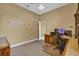 Neutral office with brown wood desk and office chair plus built in cabinets and carpet flooring at 4823 Deer Lodge Rd, New Port Richey, FL 34655