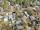 Aerial view displays neighborhood homes and tree coverage with streets below on a sunny day at 502 W Hanna Ave, Tampa, FL 33604