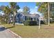 Charming blue house with a manicured front lawn and mature palm trees at 502 W Hanna Ave, Tampa, FL 33604