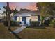 Charming blue home featuring a manicured lawn and pathway leading to the front door at 502 W Hanna Ave, Tampa, FL 33604