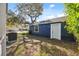 Exterior view of the detached garage with blue siding and white door at 502 W Hanna Ave, Tampa, FL 33604